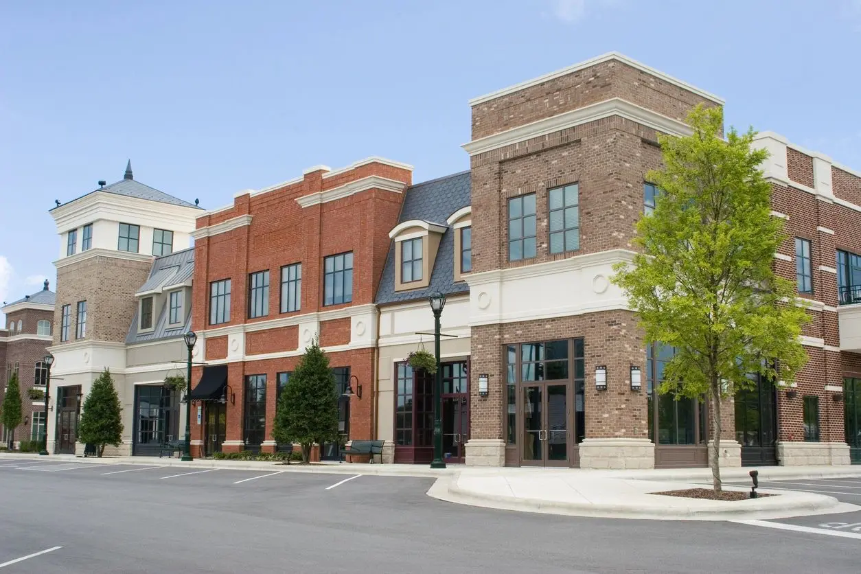 A row of modern commercial buildings under a clear blue sky.